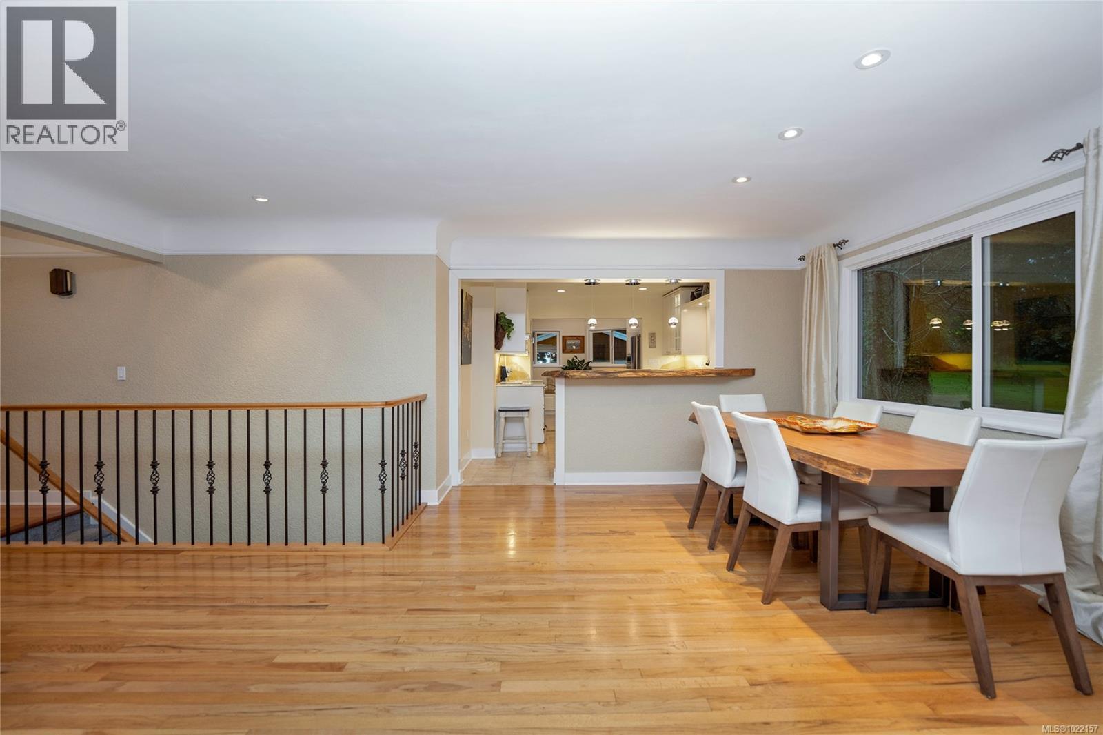 Living room with stairs to flex room below - 2229 Arbutus Rd, Saanich, BC - Indoor Photo Showing Dining Room