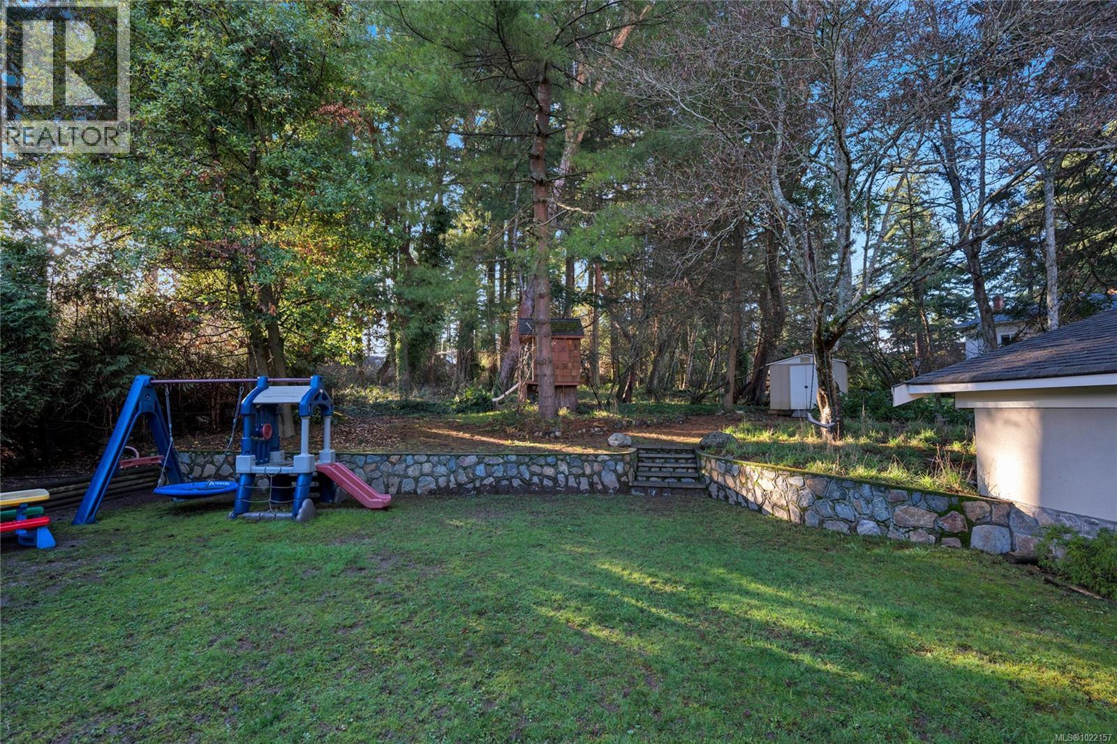 Forested back yard with playhouse - 2229 Arbutus Rd, Saanich, BC - Outdoor With Backyard
