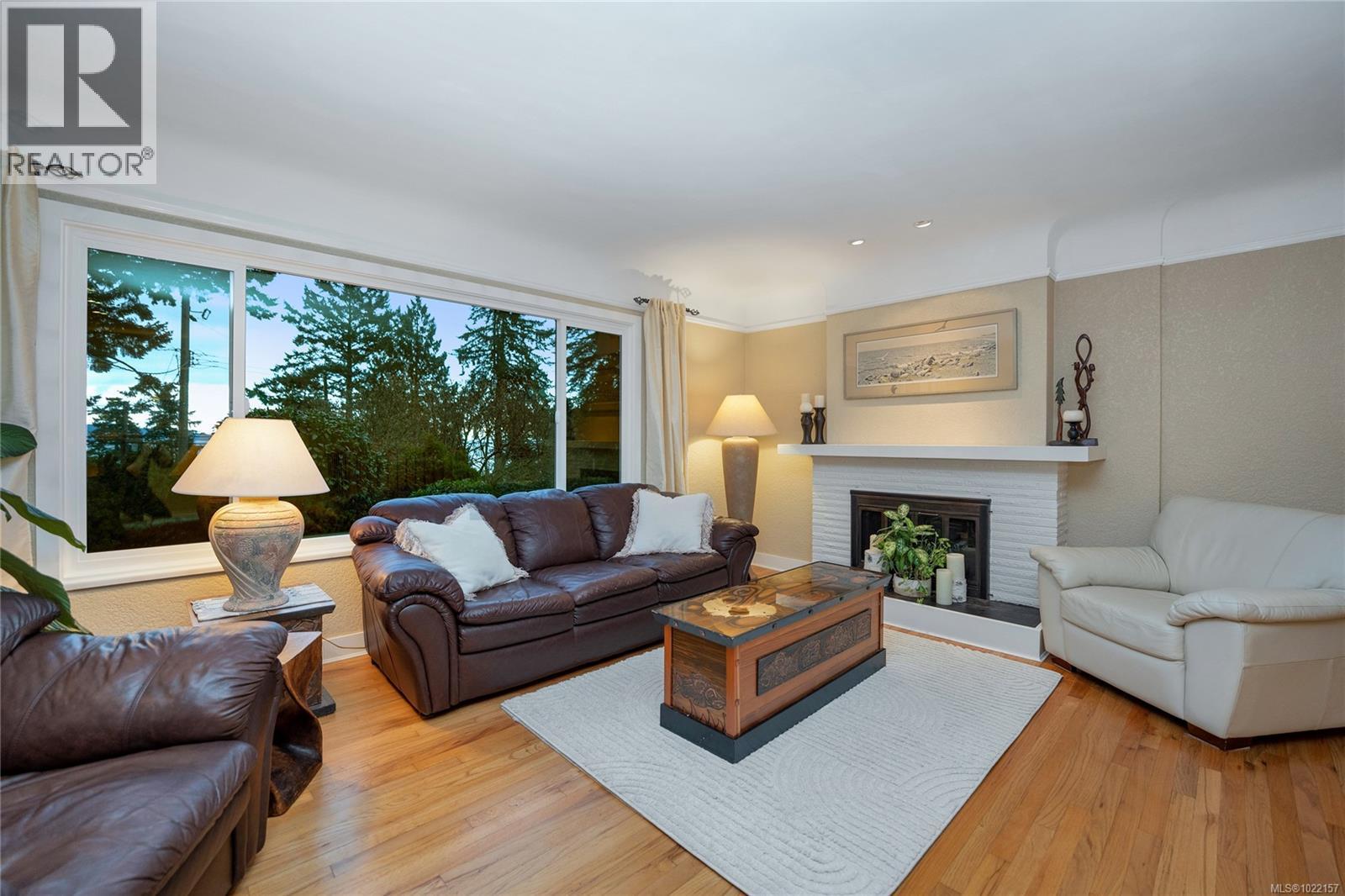 Spacious LR with water views, cove ceiling, oak hardwood floors and fireplace - 2229 Arbutus Rd, Saanich, BC - Indoor Photo Showing Living Room With Fireplace