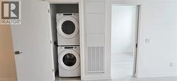 Clothes washing area featuring stacked washer / dryer -