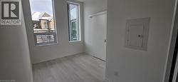 Spare room with electric panel and light hardwood / wood-style floors -