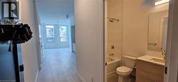 Full bathroom with bathing tub / shower combination, toilet, vanity, and hardwood / wood-style flooring -
