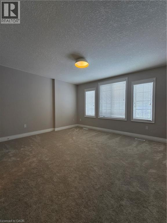 Carpeted spare room with baseboards and a textured ceiling - 93 Tremaine Drive, Kitchener, ON - Indoor Photo Showing Other Room