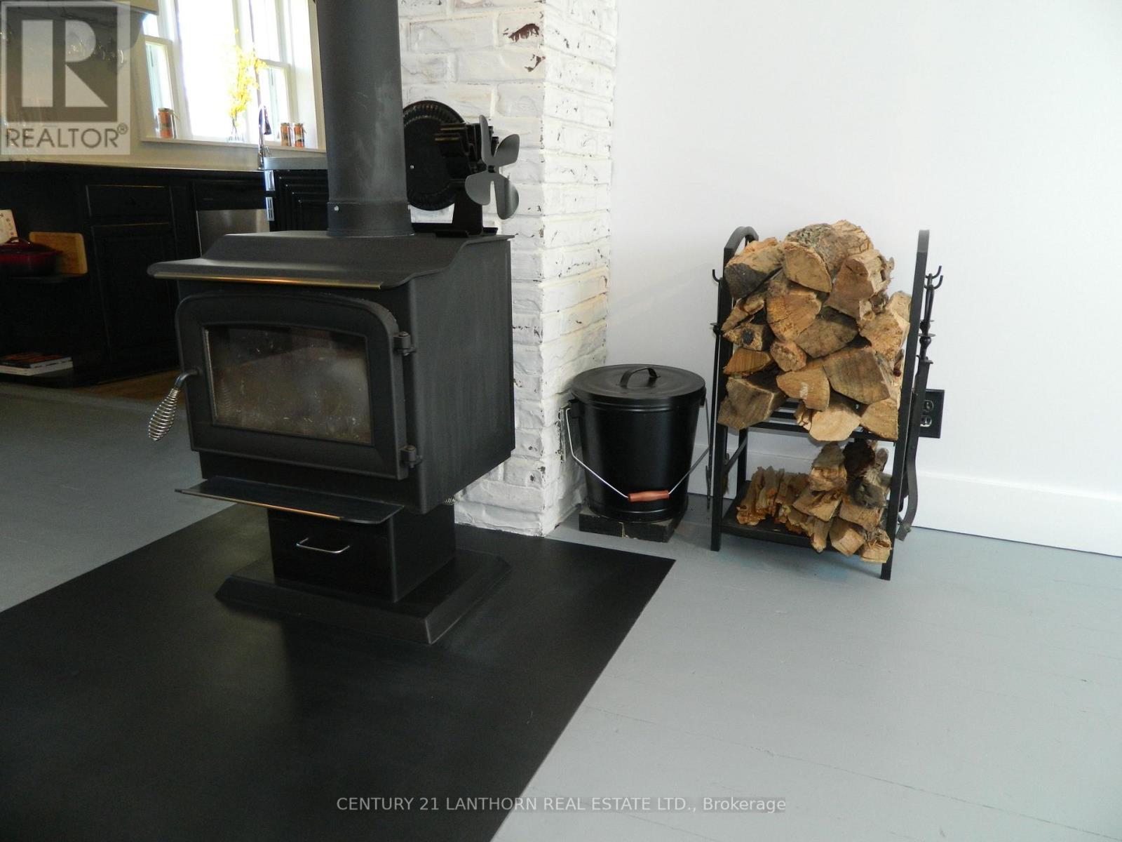 Wood stove - 644 County 10 Road, Prince Edward County (Hallowell Ward), ON - Indoor Photo Showing Other Room With Fireplace