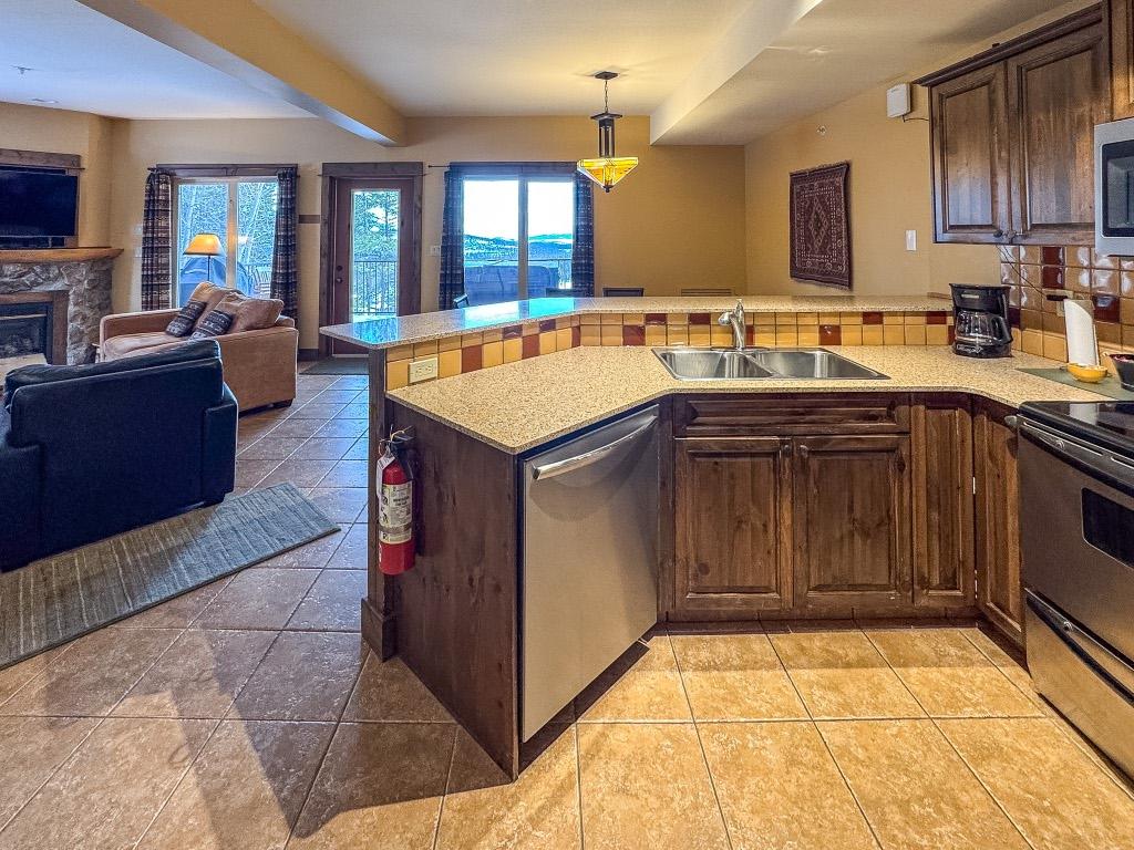 G4-A-1351 Gerry Sorensen Way, Kimberley, BC - Indoor Photo Showing Kitchen With Fireplace With Double Sink