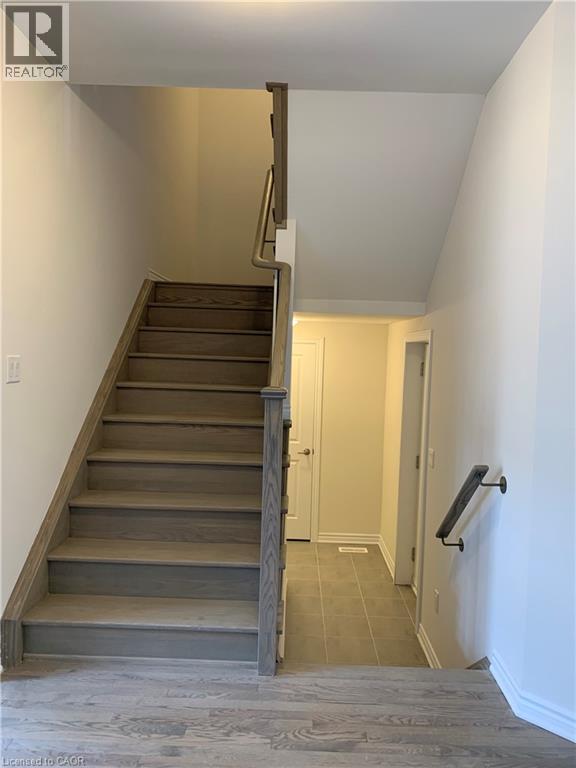 Staircase featuring baseboards and wood finished floors - 49 Eberhardt Drive, Wasaga Beach, ON - Indoor Photo Showing Other Room