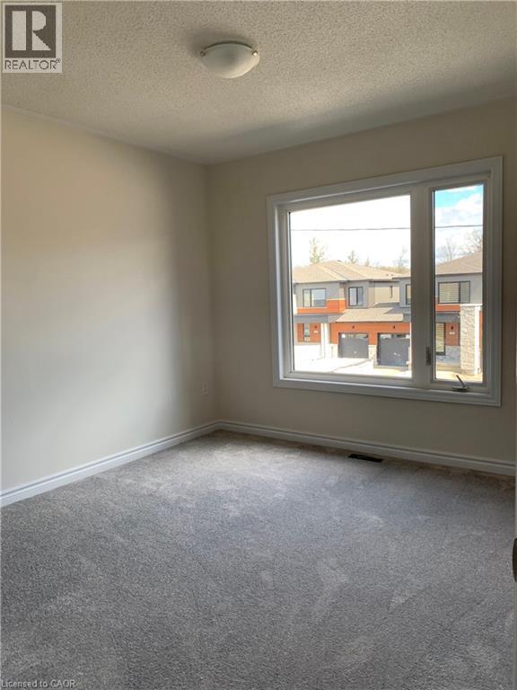 Carpeted empty room with a textured ceiling and baseboards - 49 Eberhardt Drive, Wasaga Beach, ON - Indoor Photo Showing Other Room