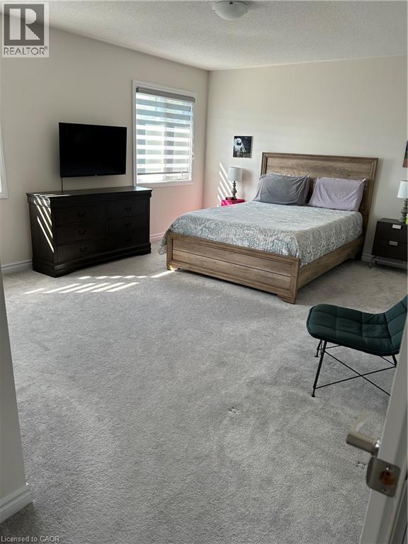 Bedroom with carpet and a textured ceiling - 49 Eberhardt Drive, Wasaga Beach, ON - Indoor Photo Showing Bedroom