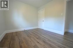 Empty room featuring baseboards and wood finished floors -