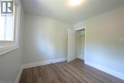 Unfurnished bedroom featuring wood finished floors and a closet -