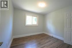 Spare room featuring baseboards and dark wood-type flooring -