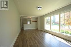 Spare room with dark wood-style flooring and baseboards -