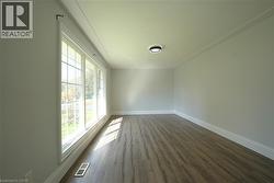 Spare room with dark wood-style flooring and baseboards -