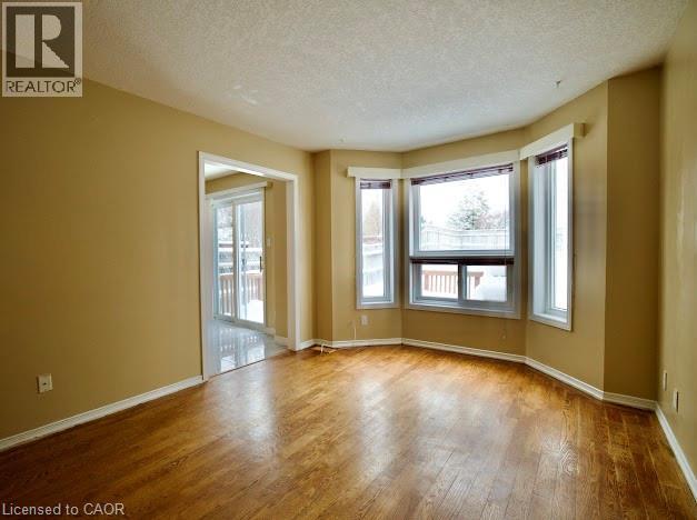 Spare room featuring a textured ceiling and hardwood / wood-style flooring - 109 Beechmanor Crescent, Kitchener, ON - Indoor Photo Showing Other Room