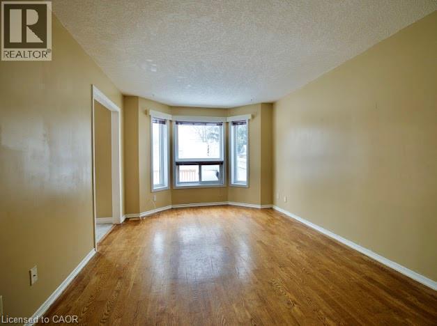 Unfurnished room with a textured ceiling and wood finished floors - 109 Beechmanor Crescent, Kitchener, ON - Indoor Photo Showing Other Room