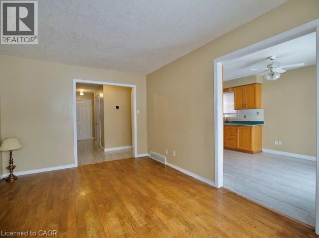 Unfurnished living room with light wood-type flooring, a textured ceiling, and a ceiling fan - 109 Beechmanor Crescent, Kitchener, ON - Indoor Photo Showing Other Room