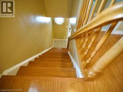 Stairs with wood finished floors and baseboards -