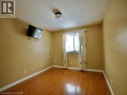 Empty room with wood finished floors and a textured ceiling -