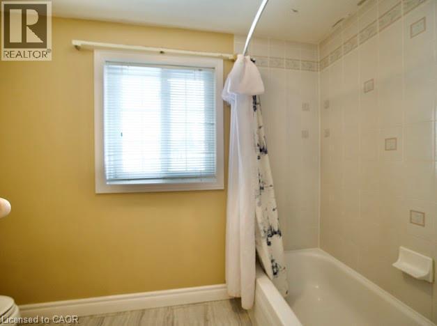 Bathroom featuring shower / tub combo and baseboards - 109 Beechmanor Crescent, Kitchener, ON - Indoor Photo Showing Bathroom