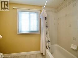 Bathroom featuring shower / tub combo and baseboards -