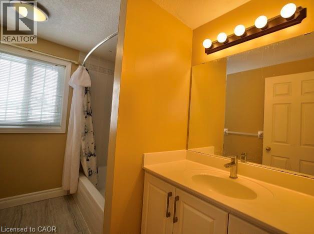 Bathroom featuring shower / bath combination with curtain, vanity, and a textured ceiling - 109 Beechmanor Crescent, Kitchener, ON - Indoor Photo Showing Bathroom