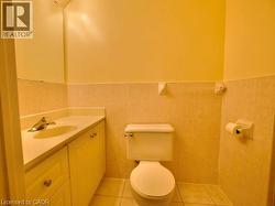 Bathroom featuring vanity, light tile patterned floors, tile walls, and wainscoting -
