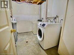 Washroom with concrete floors and washer and clothes dryer -