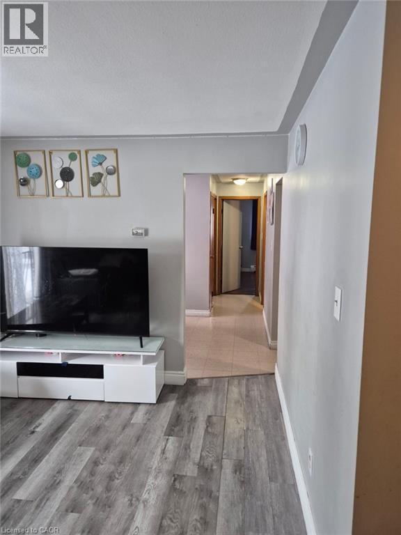 Unfurnished living room featuring light wood-style flooring and a textured ceiling - 76 Brybeck Crescent Unit# 204, Kitchener, ON - Indoor