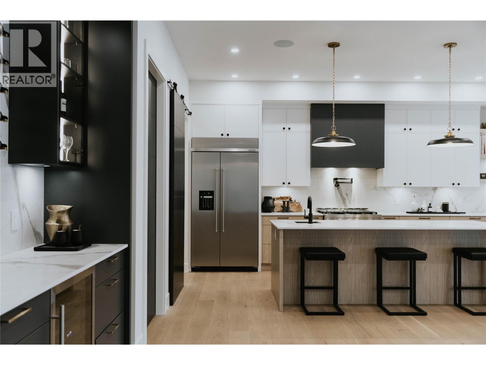 A seamlessly integrated built-in fridge enhances the kitchen's sleek, high end design. - 5533 Foothill Court, Kelowna, BC - Indoor Photo Showing Kitchen With Upgraded Kitchen