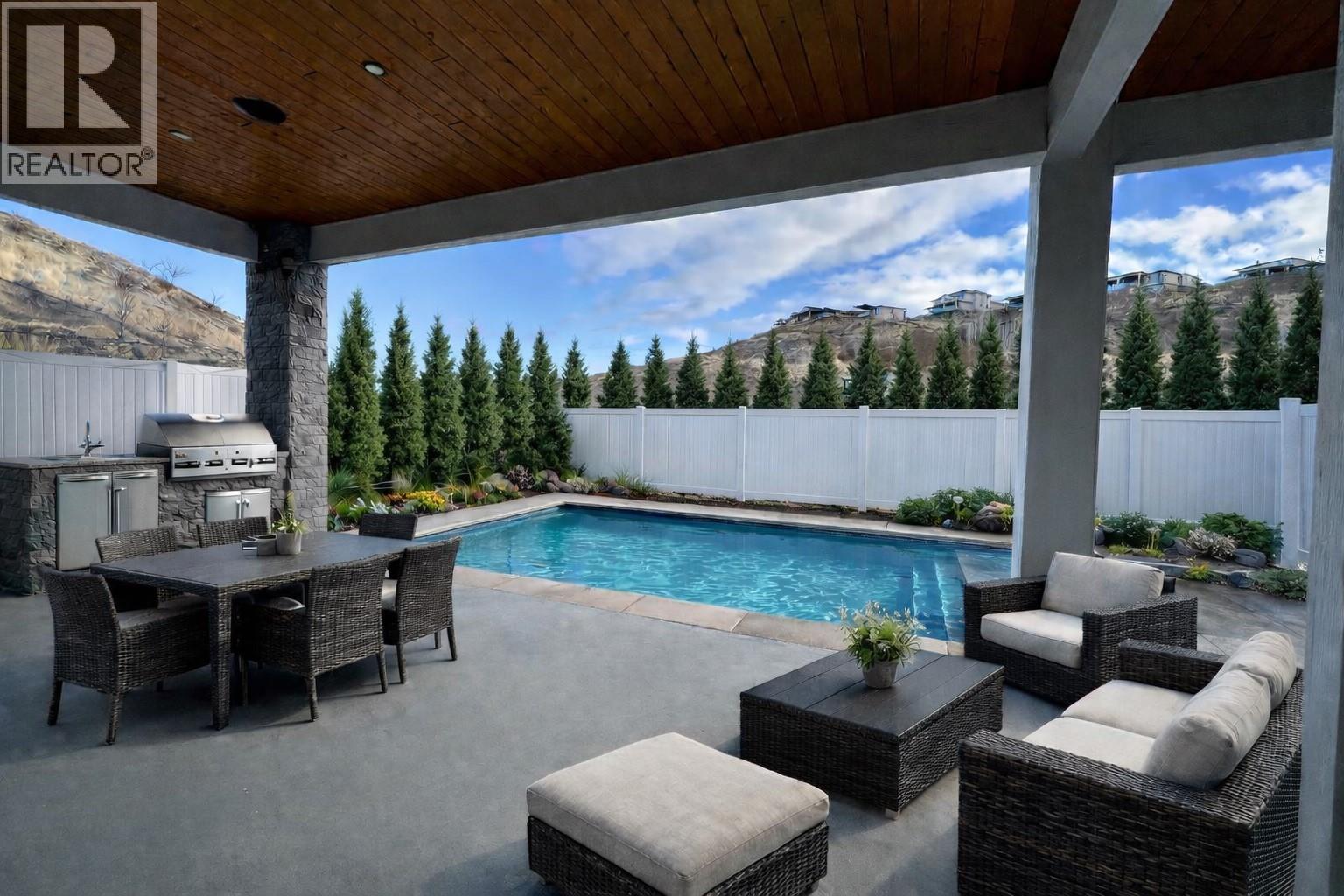 AI-generated images for visualization purposes only. Pool is scheduled to be completed in Spring. Outdoor kitchen, bbq, furniture and landscaping shown are digitally added. - 5533 Foothill Court, Kelowna, BC - Outdoor With In Ground Pool With Deck Patio Veranda