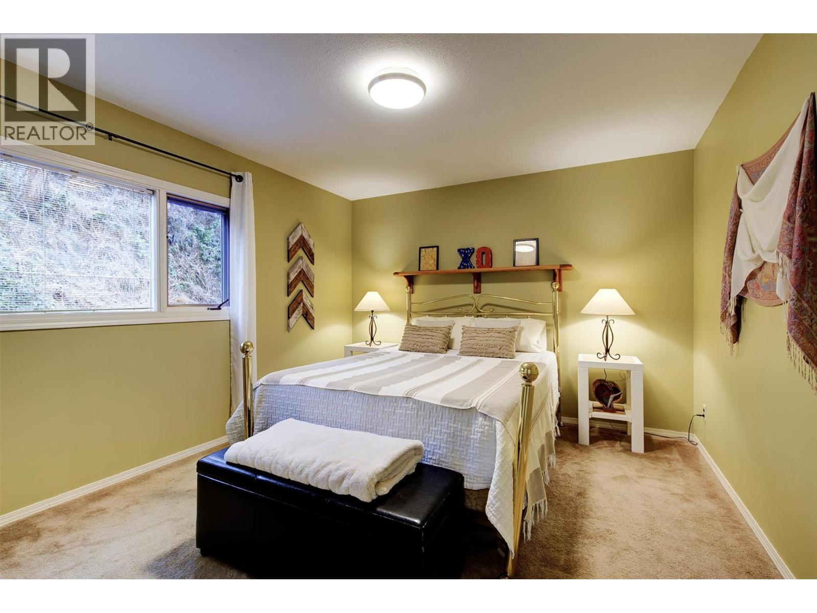 Main floor 2nd bedroom with window to back yard - 391 Braeloch Road, Kelowna, BC - Indoor Photo Showing Bedroom