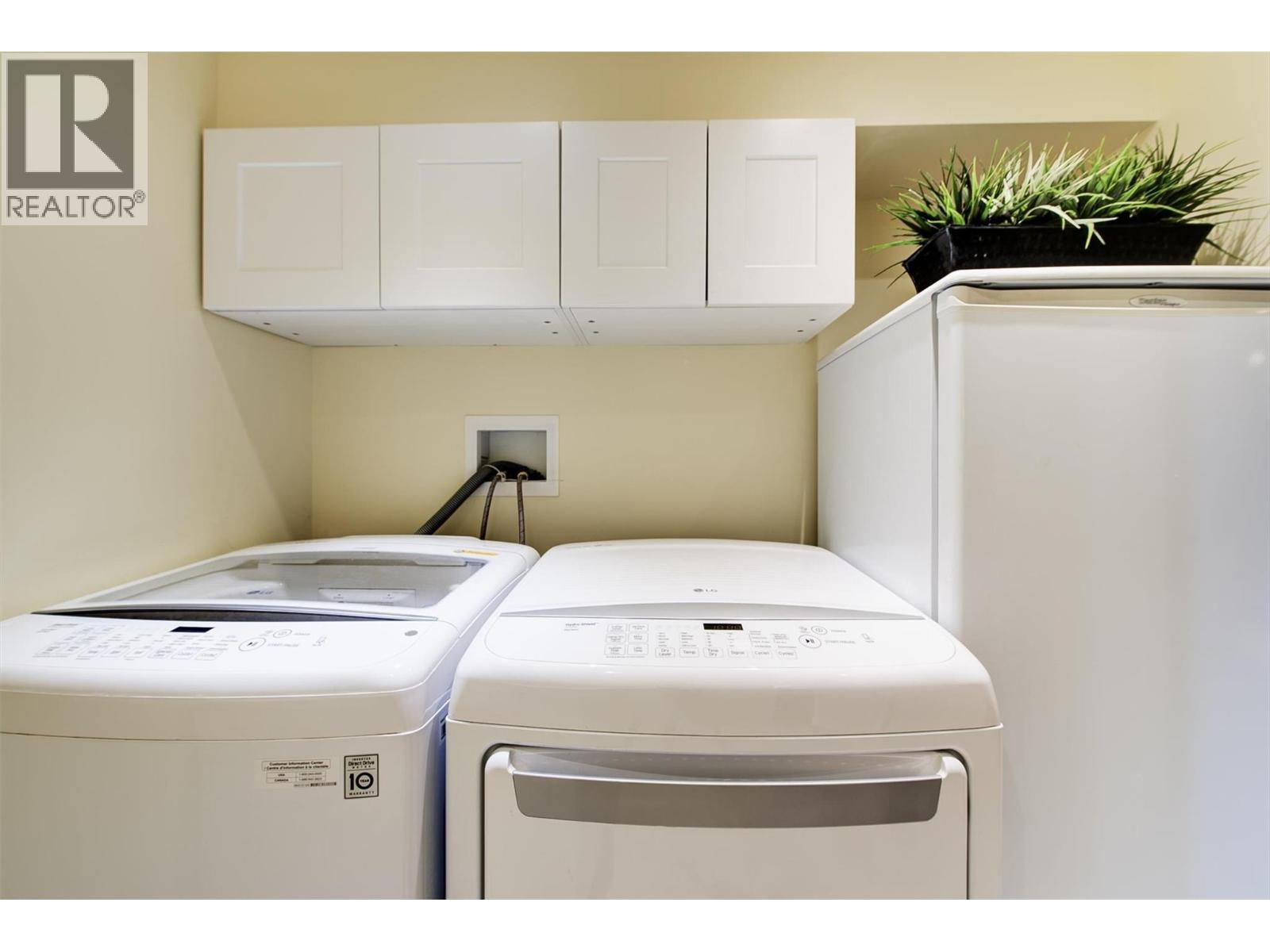Built in cabinets over washer and dryer - 391 Braeloch Road, Kelowna, BC - Indoor Photo Showing Laundry Room