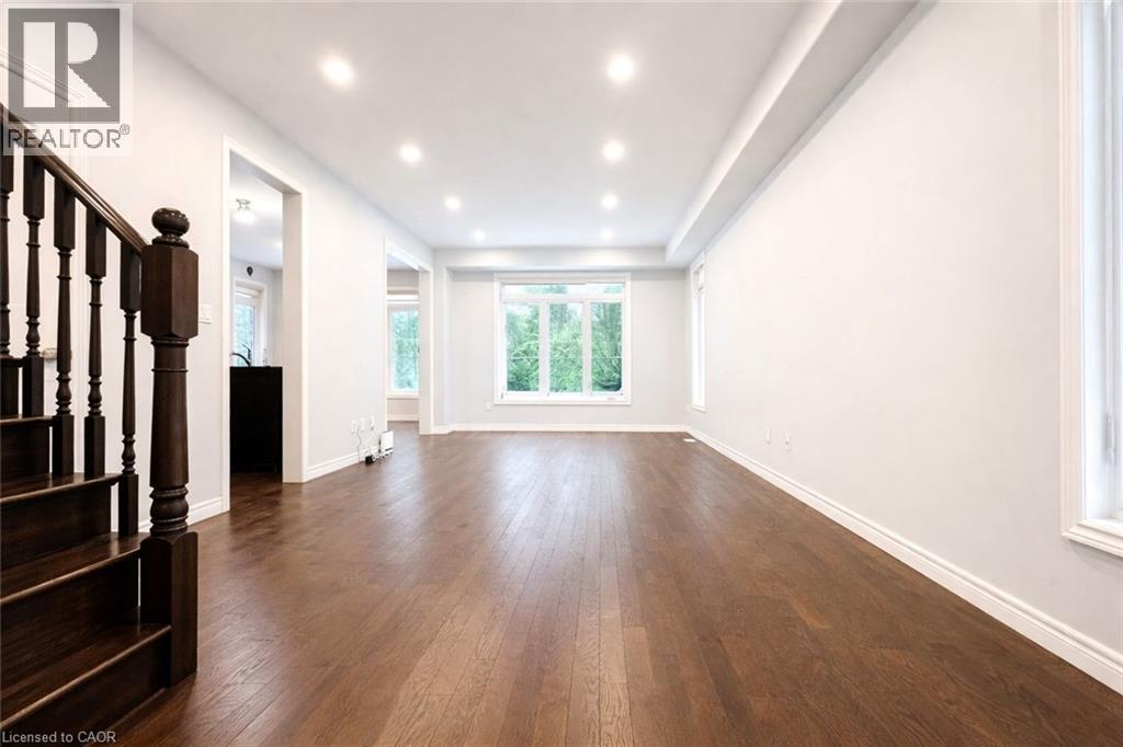 Unfurnished living room with stairs, dark wood-style flooring, and recessed lighting - 127 Elmbank Trail Unit# Upper, Kitchener, ON - Indoor Photo Showing Other Room