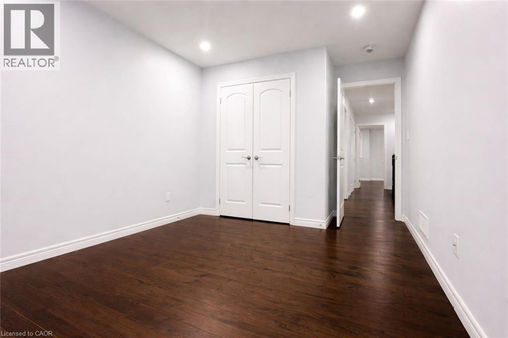 Unfurnished bedroom with dark wood-style floors, recessed lighting, and a closet - 127 Elmbank Trail Unit# Upper, Kitchener, ON - Indoor Photo Showing Other Room