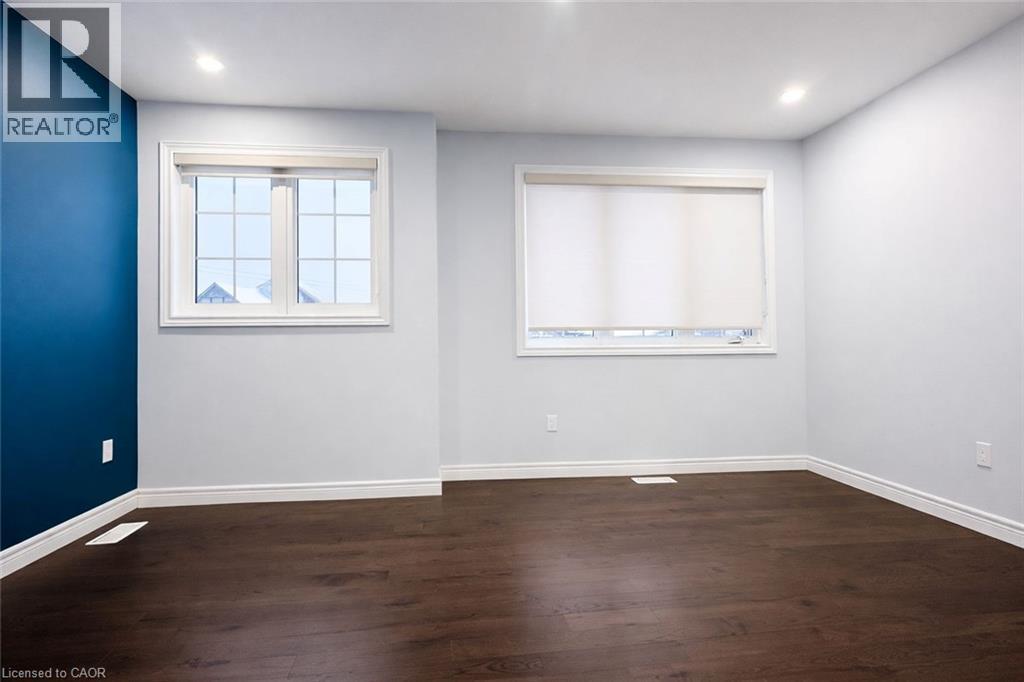 Empty room with dark wood-style floors and recessed lighting - 127 Elmbank Trail Unit# Upper, Kitchener, ON - Indoor Photo Showing Other Room