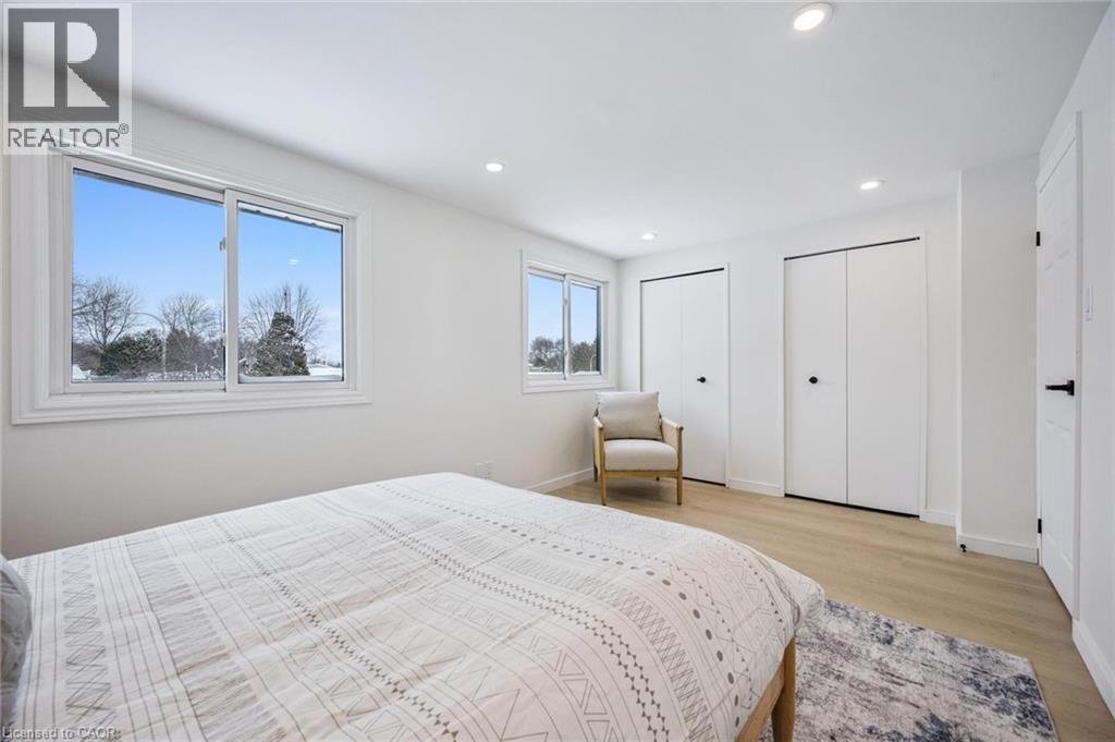 Bedroom featuring two closets, light wood-style floors, and recessed lighting - 21 Forest Glen Court, Kitchener, ON - Indoor Photo Showing Bedroom