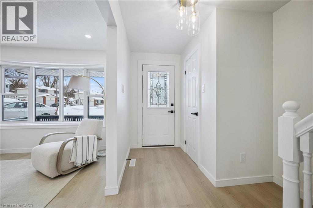 Entrance foyer featuring light wood-style floors, plenty of natural light, and a chandelier - 21 Forest Glen Court, Kitchener, ON - Indoor Photo Showing Other Room