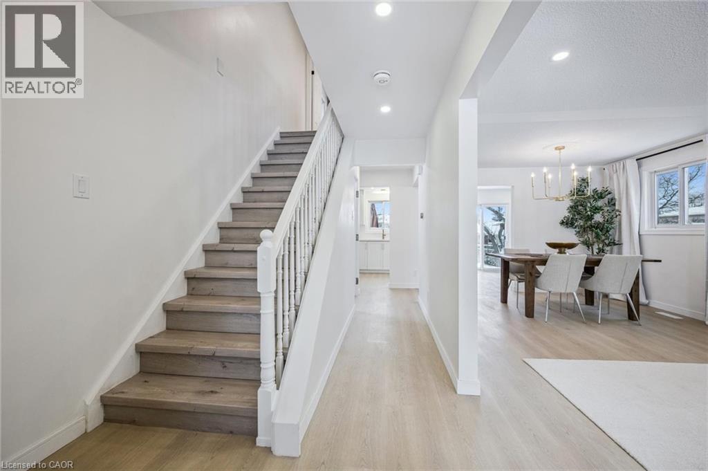 Stairs with wood finished floors, a chandelier, and recessed lighting - 21 Forest Glen Court, Kitchener, ON - Indoor Photo Showing Other Room