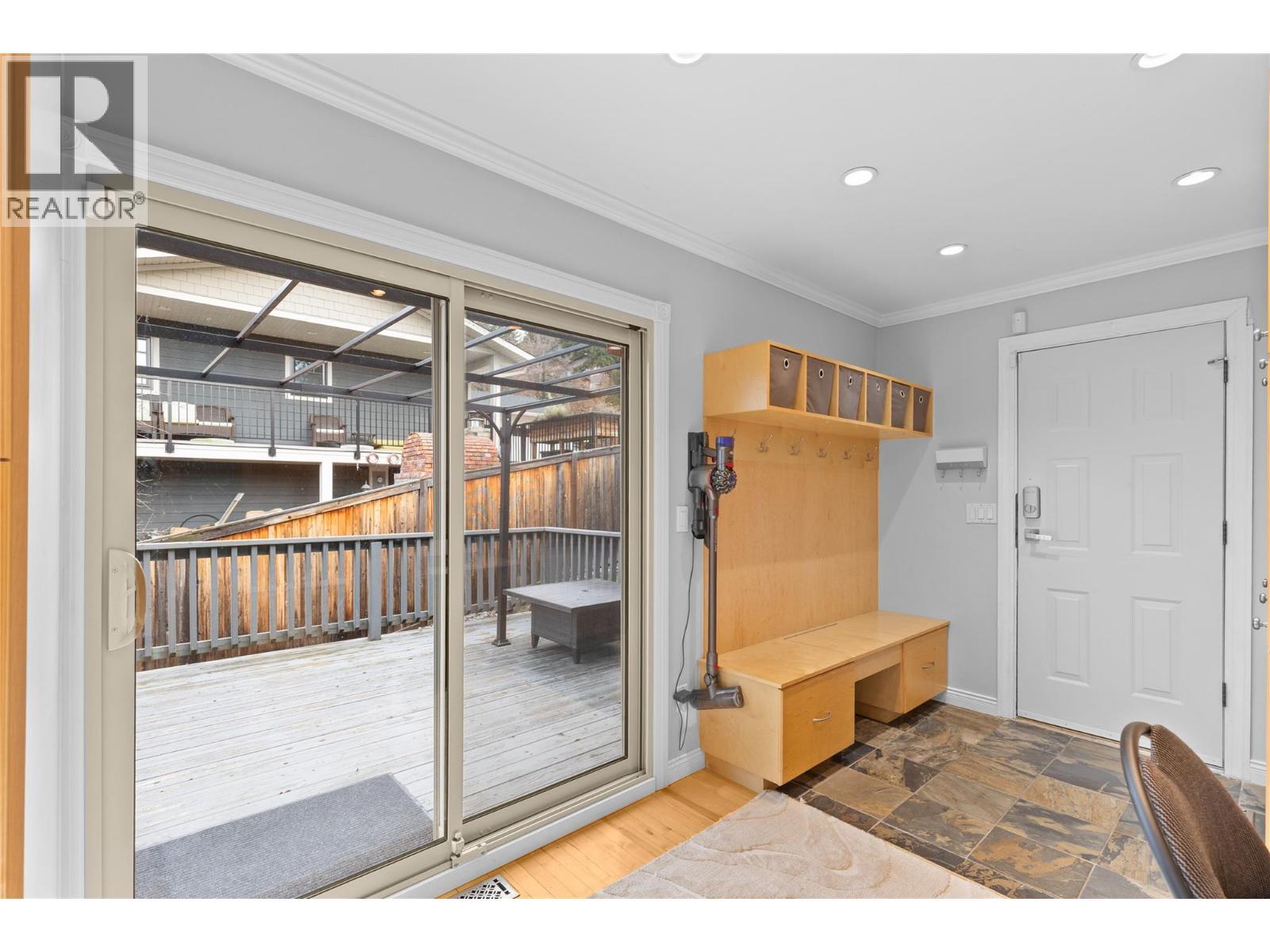 Patio doors leading to deck with hot tub - 11609 Upper Summit Drive, Coldstream, BC - Indoor Photo Showing Other Room
