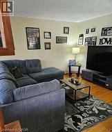 Living room featuring wood finished floors and crown molding -