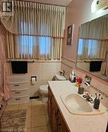 Full bathroom featuring vanity, tile walls, and dark tile patterned flooring -
