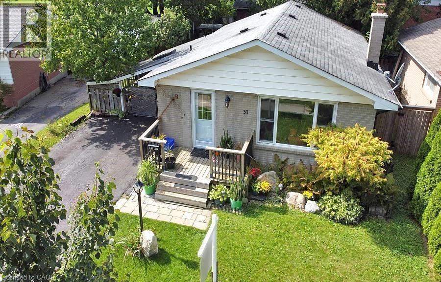 View of front facade featuring brick siding, a wooden deck, and a chimney - 33 Garland Crescent, London, ON - Outdoor With Deck Patio Veranda
