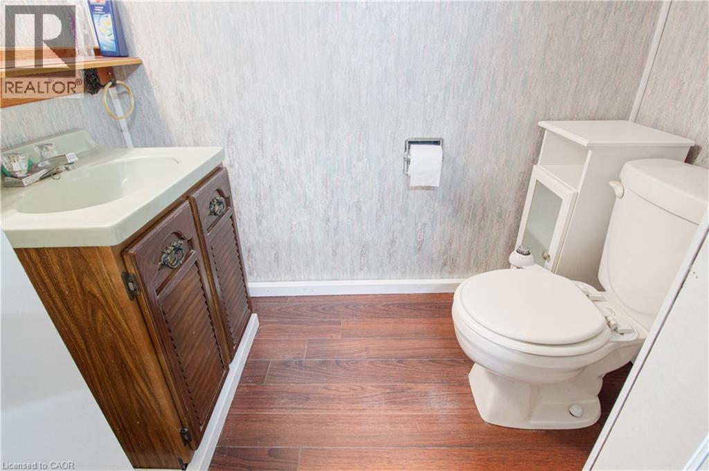 Bathroom featuring vanity, dark wood finished floors, and wallpapered walls - 773 Queensdale Avenue E, Hamilton, ON - Indoor Photo Showing Bathroom