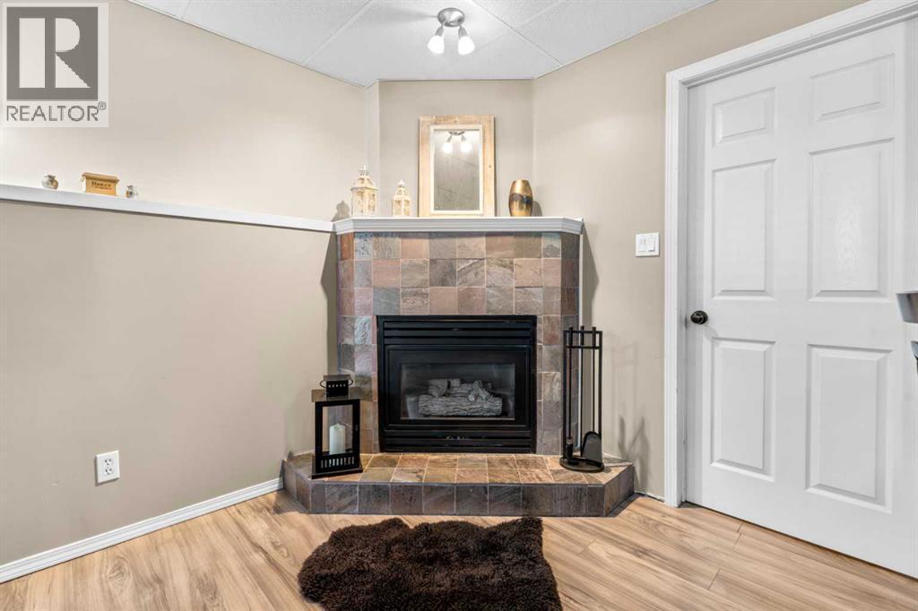 Fireplace in the basement - 6 Easterbrook Place Se, Airdrie, AB - Indoor Photo Showing Living Room With Fireplace