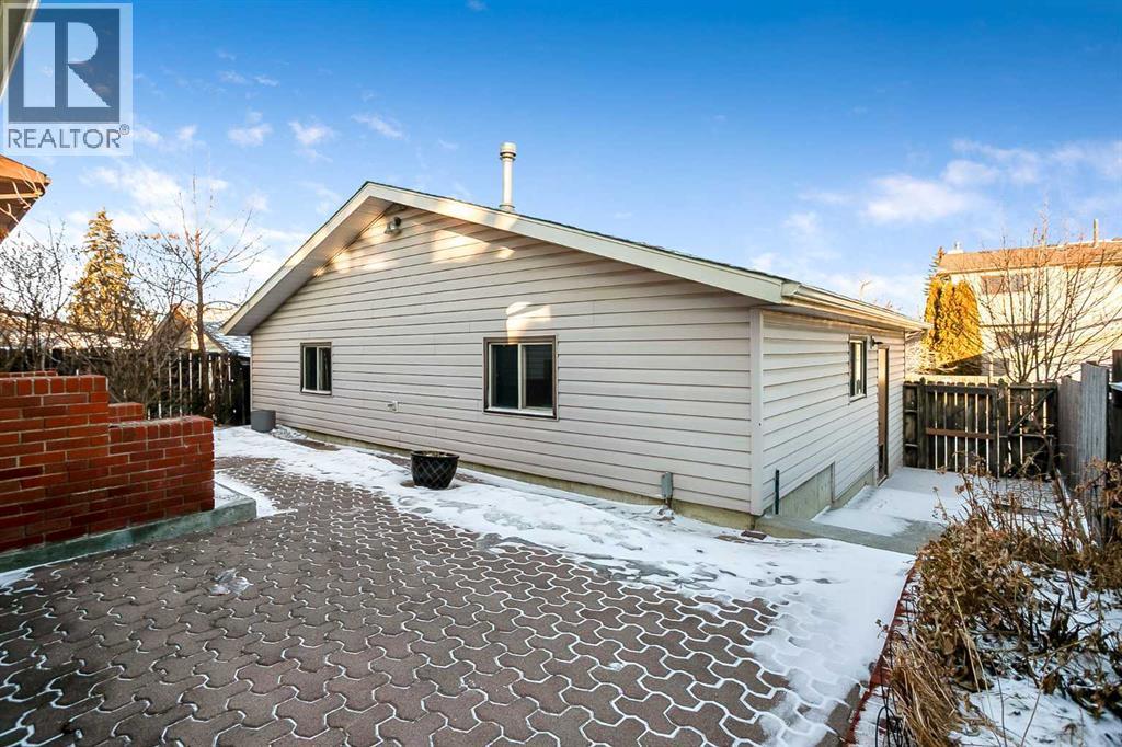 Low maintenance landscaping with a large patio space and a RARE Triple car garage with heat! - 467 Berkley Crescent Nw, Calgary, AB - Outdoor With Exterior