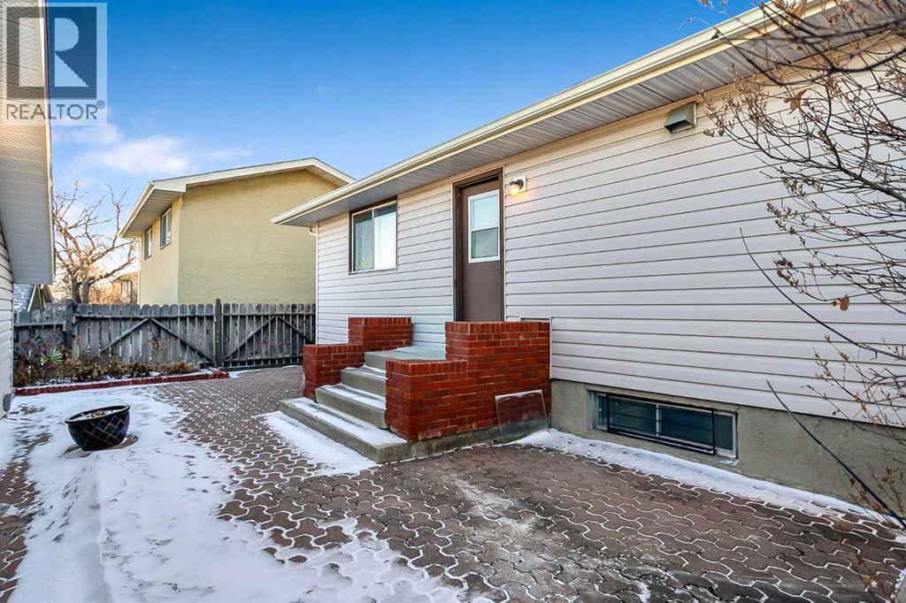 Low maintenance landscaping with a large patio space and a RARE Triple car garage with heat! - 467 Berkley Crescent Nw, Calgary, AB - Outdoor With Exterior