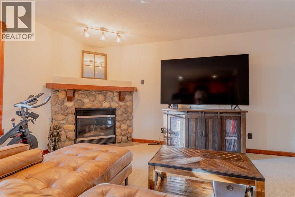 313, 170 Crossbow Place, Canmore, AB - Indoor Photo Showing Living Room With Fireplace