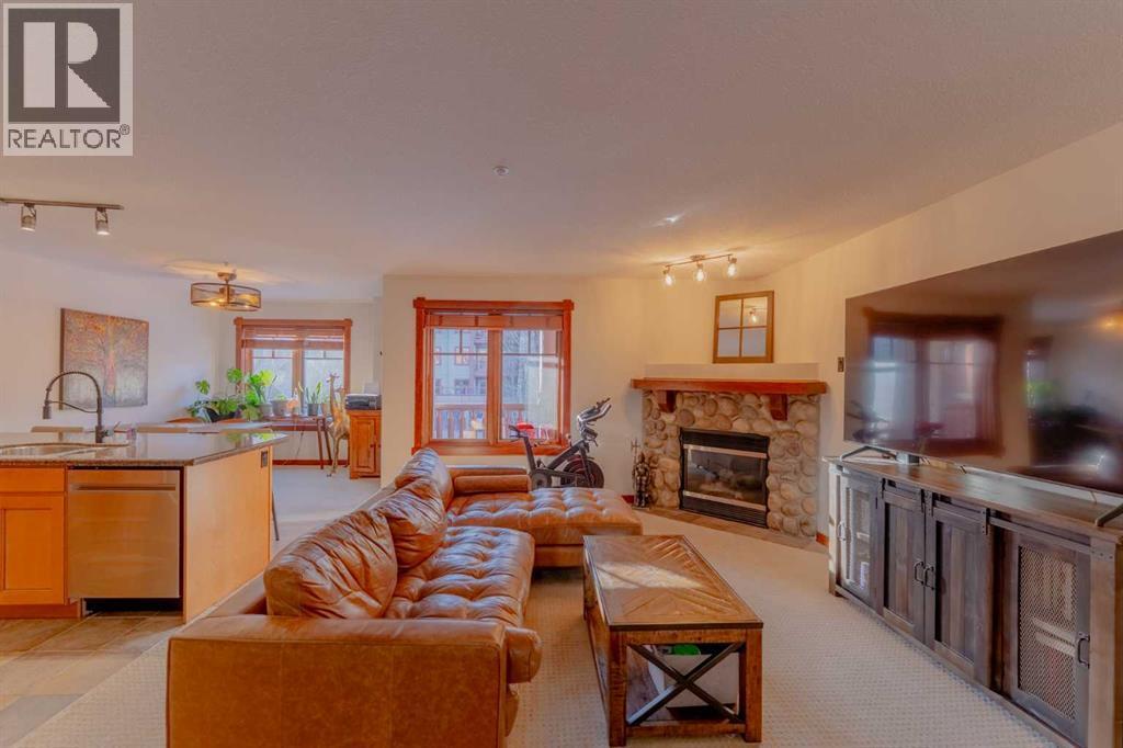 313, 170 Crossbow Place, Canmore, AB - Indoor Photo Showing Living Room With Fireplace