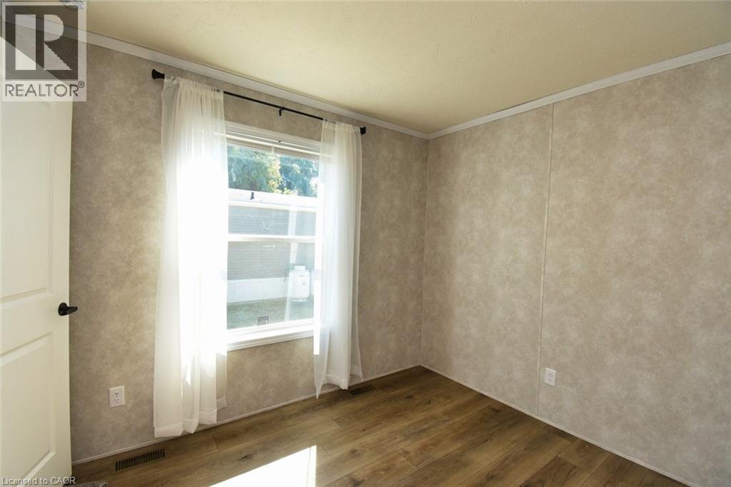 Empty room featuring dark wood-type flooring and ornamental molding - 1085 Concession 10 Road W Unit# 23, Flamborough, ON - Indoor Photo Showing Other Room