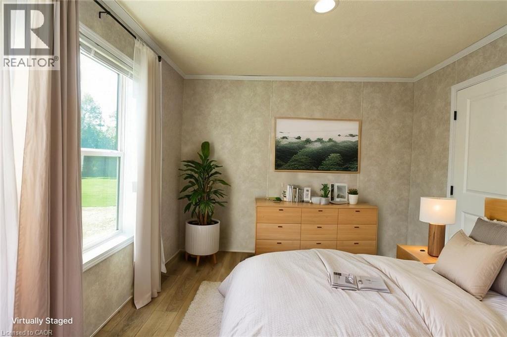 Bedroom featuring wood finished floors and crown molding - 1085 Concession 10 Road W Unit# 23, Flamborough, ON - Indoor Photo Showing Bedroom